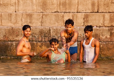 VARANASI, INDIA - APRIL 24: Unidentified young men taking ritual bath in the river Ganga on April 24, 2011 in the holy city of Varanasi, India. The holy ritual bath is held every day.