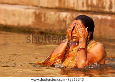 VARANASI, INDIA - APRIL 25: Unidentified woman washes her face in the river Ganga on April 25, 2011 in the holy city of Varanasi, India. The holy ritual of washing is held every day.