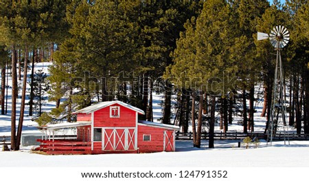 Winter scene of red barn trees snow and windmill