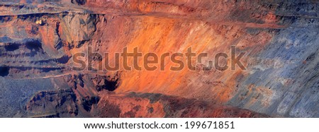 excavator against iron-ore pit