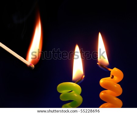 Candle and match on a black background