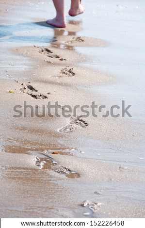 person walking barefoot on the shore of the indian ocean in africa