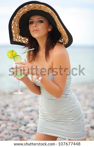 sexy girl with a cocktail by the sea