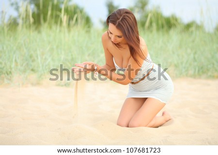 girl throws sand at the beach