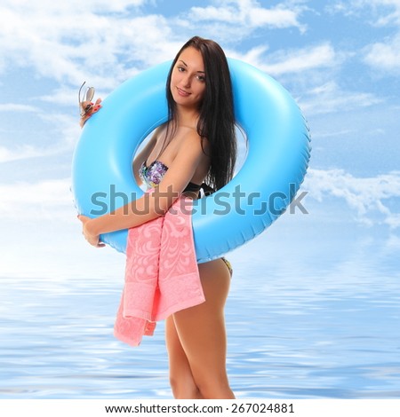 sexy female in bikini holding swimming ring