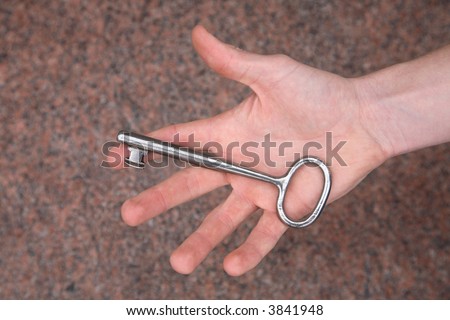 Open hand holding the huge key to the Castle Kronborg in Elsinore, Denmark.