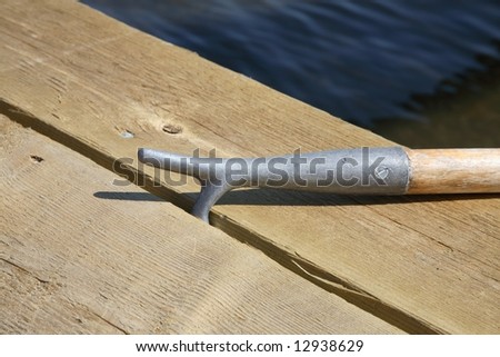 Boat hook with a safe grip at a gap between the boards in the landing stage