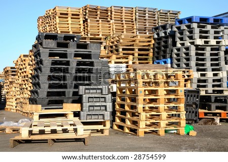 Stacks of pallets outside a fish auction and export industry.