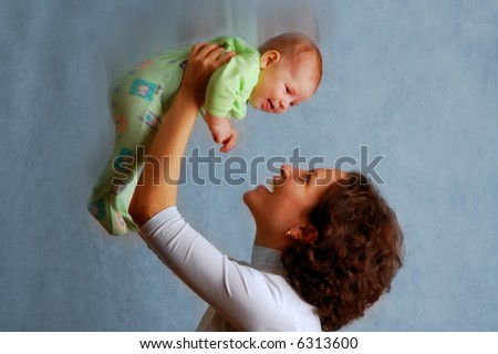 happy little baby In hands of mother (photographic studio with use of three flashes)
