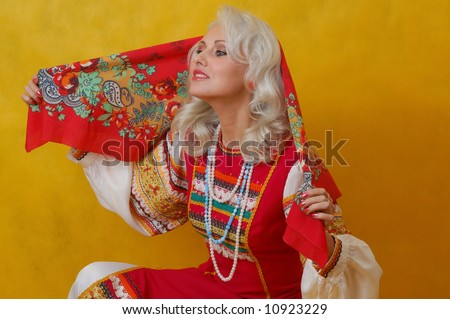 a beautiful woman in a folk russian dress on yellow background