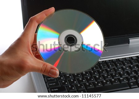 Close up. Woman with cd disk in a hand used notebook. White background