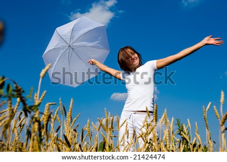 Beautiful asian girl under blue sky with umbrella in the field.
