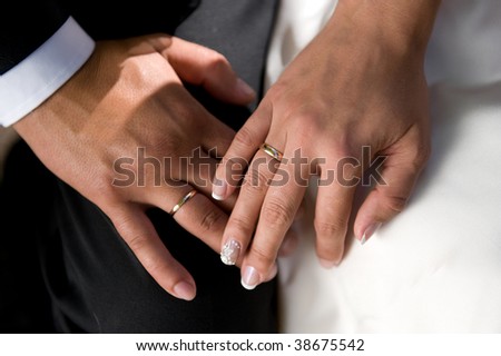 Close-up golden rings on the fingers of couple. Wedding day