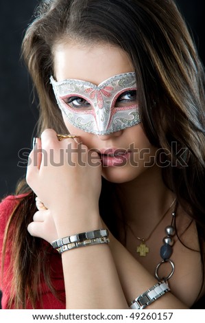 Portrait of mysterious woman\'s face behind ornate white and silver mask