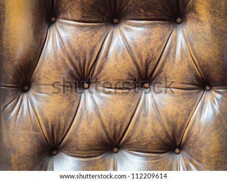 Detail of an old vintage brown couch with buttons
