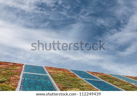 Solar panels on a new roof covered with green and red sedum for isolation and heating