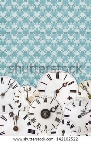 Different white vintage clock faces on a retro blue wallpaper background
