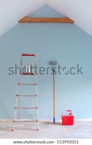 Paint Tools With Ladder Against A Newly Painted Light Blue Wall