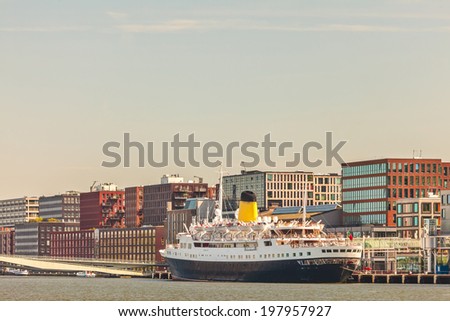 View at the Amsterdam KSNM island with a classic cruise liner in front