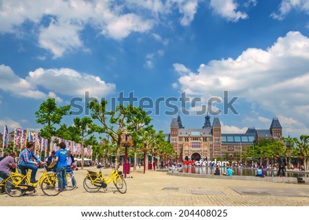 AMSTERDAM, THE NETHERLANDS - JUNE 26, 2014: Tourists with bicycles in front of the Rijksmuseum in Amsterdam, The Netherlands
