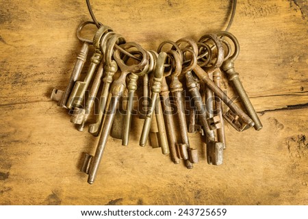 Set of old keys hanging on a ring in front of a wooden background