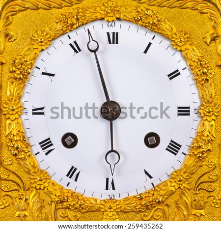 Ancient ornamental golden clock face with white base plate