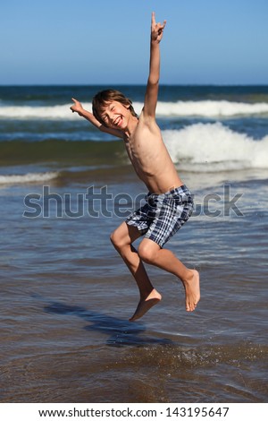 happy boy jumping by the ocean