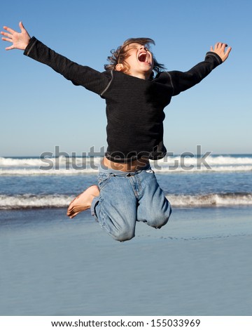 boy jumping high by the ocean