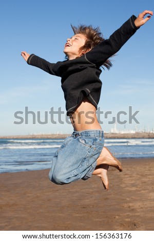 boy jumping by the ocean