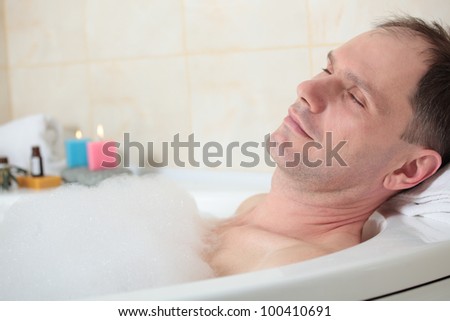 Adult man having a bath with essential oil