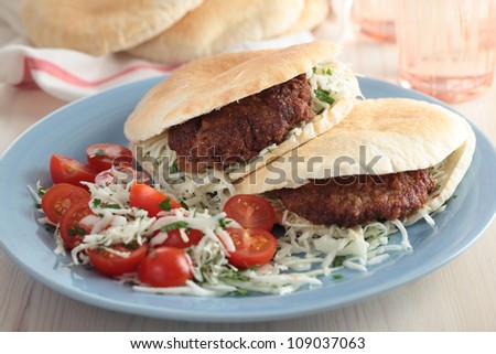 Pita bread filled with breaded steak and cabbage with cherry tomato
