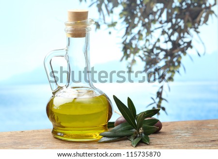 Olive oil in a jug and olive branch with fruits