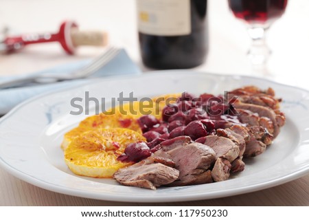 Roasted duck meat with sliced orange and cherry sauce