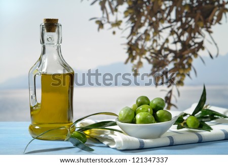 Olives and olive oil against Mediterranean landscape