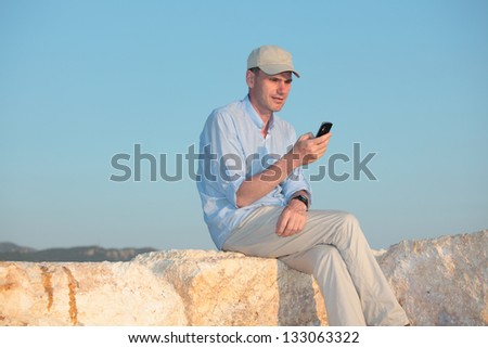Man with mobile phone against a sea