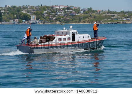 SEVASTOPOL, UKRAINE - MAY 8: Boat of commander of Russian navy go to the military ship anchored in the harbor of Sevastopol, Crimea, Ukraine on May 8, 2013