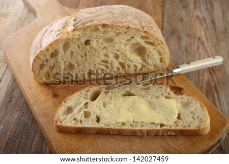 Bread with butter on a rustic cutting board