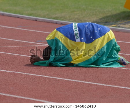 DONETSK, UKRAINE - JULY 14: Silver medalist in 200 metres Vitor Hugo dos Santos of Brazil under national flag during 8th IAAF World Youth Championships in Donetsk, Ukraine on July 14, 2013