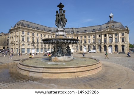 BORDEAUX, FRANCE - JUNE 27: People walks on the Place de la Bourse in Bordeaux, France on June 27, 2013. The fountain of Three Graces in the center of square was erected in 1869