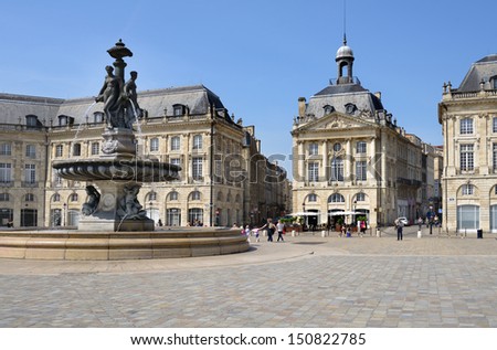 Bordeaux, France - June 27: People Walks On The Place De La Bourse In Bordeaux, France On June 27, 2013. The Fountain Of Three Graces In The Center Of Square Was Erected In 1869