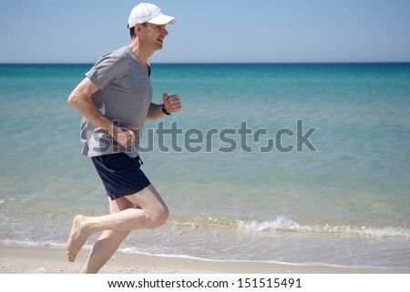 Barefoot man jogging on a beach