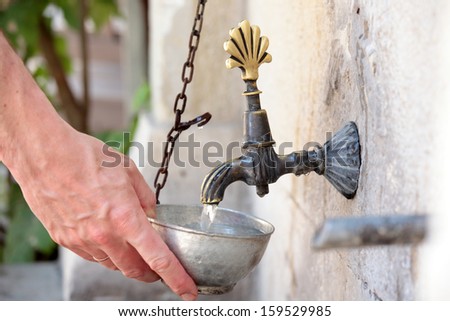 Man taking potable water in a street side tap