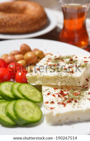 Turkish breakfast with cheese, vegetables, simit, and tea