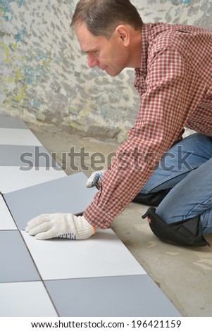 Tiler install ceramic tiles on a floor