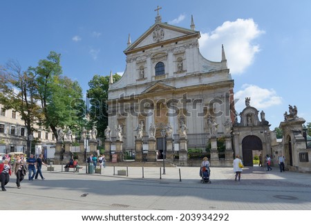 KRAKOW, POLAND - SEPTEMBER 15, 2013: People under the Church of Saints Apostles Peter and Paul known best for the statues of the 12 disciples lining the fence. It\'s the first baroque church in Krakow