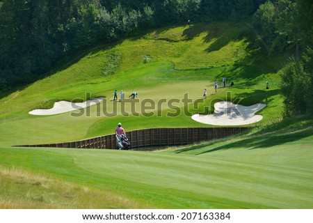 TSELEEVO, MOSCOW REGION, RUSSIA - JULY 24, 2014: Golfers on the golf course in the Tseleevo Golf & Polo Club during the M2M Russian Open. This golf tournament is the stage of the European Tour