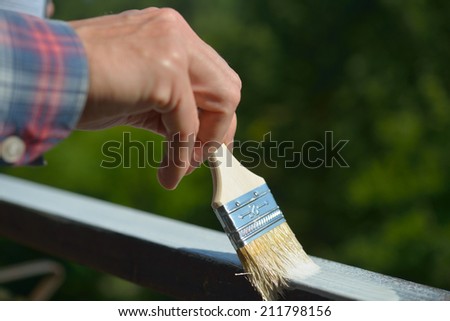Man painting a guard rail on a balcony