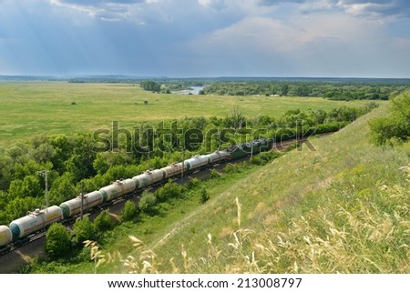 DIVNOGORIE, VORONEZH REGION, RUSSIA - JUNE 8, 2014: Freight train against the landscape of Don river. Russia holds the second place, after China, by the length of electrified railroads