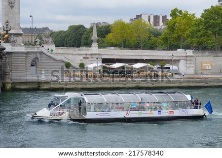 PARIS, FRANCE - SEPTEMBER 12, 2013: People on the boat making the tour on Seine river. River cruises are the favorite leisure activity for thousands of tourists