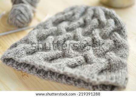 Knitted hat and knitting needles on a table
